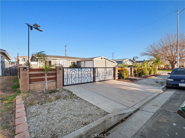 view of gate with a fenced front yard and a residential view