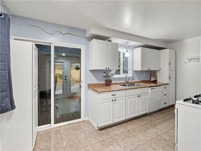 kitchen with white appliances, light tile patterned floors, french doors, white cabinetry, and a sink