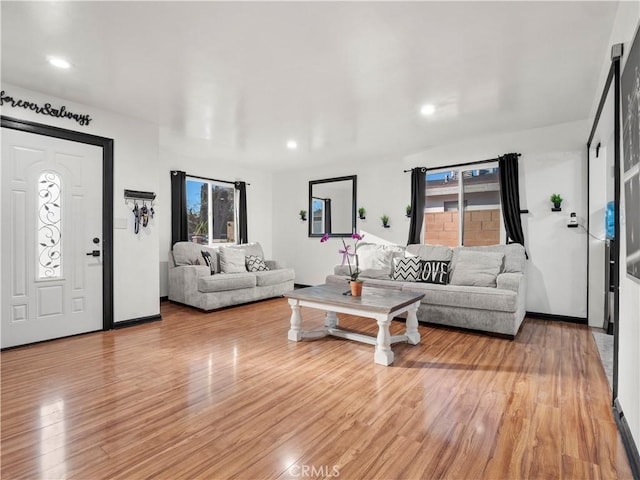 living area featuring light wood-type flooring, a wealth of natural light, and recessed lighting