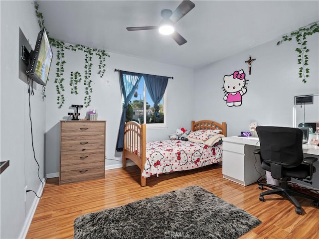 bedroom with ceiling fan, baseboards, and wood finished floors