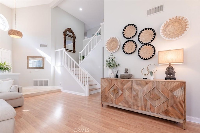 interior space with stairs, wood finished floors, and visible vents