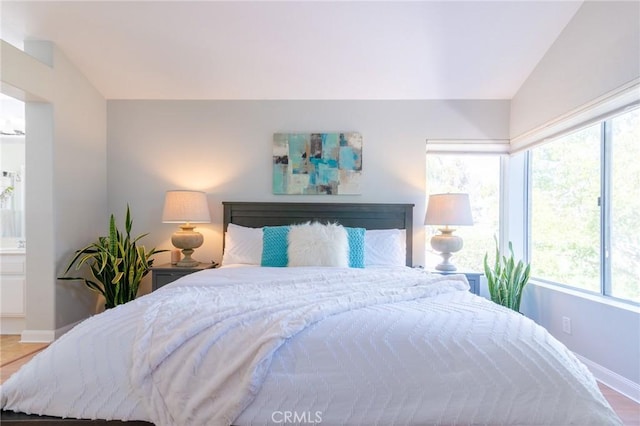 bedroom with baseboards and vaulted ceiling