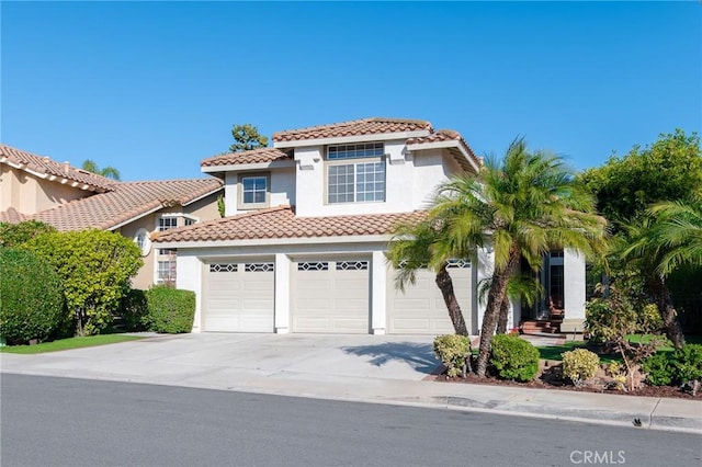 mediterranean / spanish-style house featuring a garage, concrete driveway, a tile roof, and stucco siding