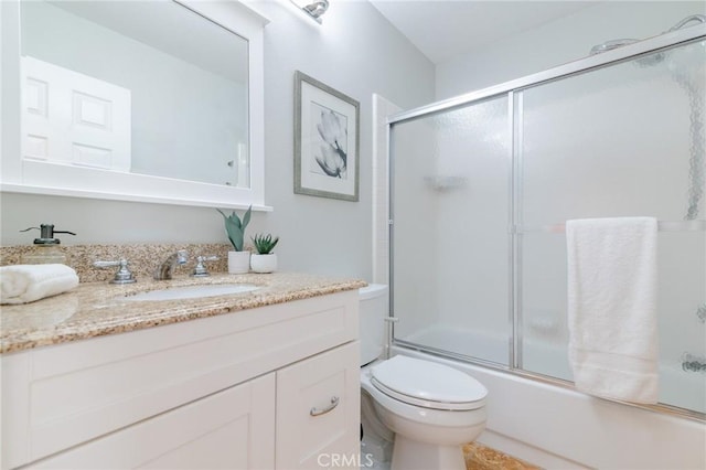 full bath featuring enclosed tub / shower combo, vanity, and toilet