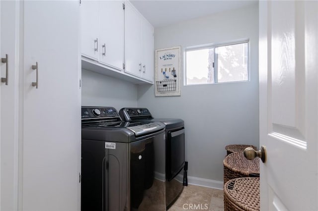 washroom featuring cabinet space, washing machine and dryer, and baseboards