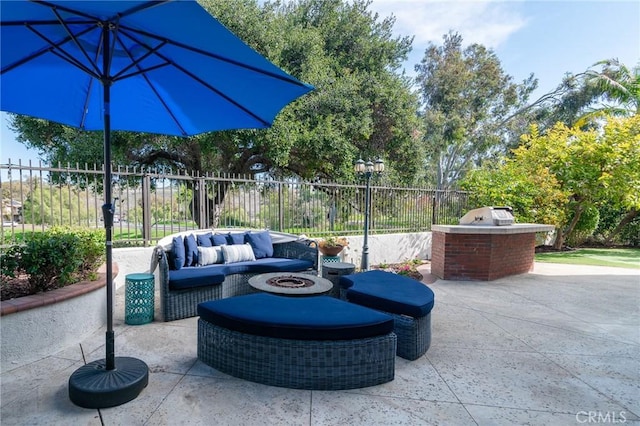 view of patio / terrace with an outdoor living space with a fire pit, an outdoor kitchen, and fence