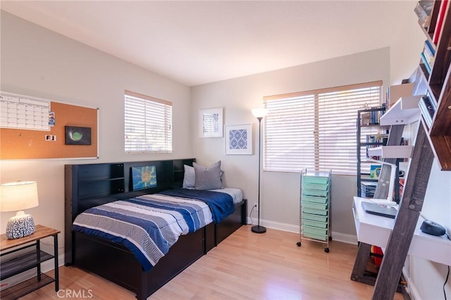 bedroom featuring baseboards and wood finished floors