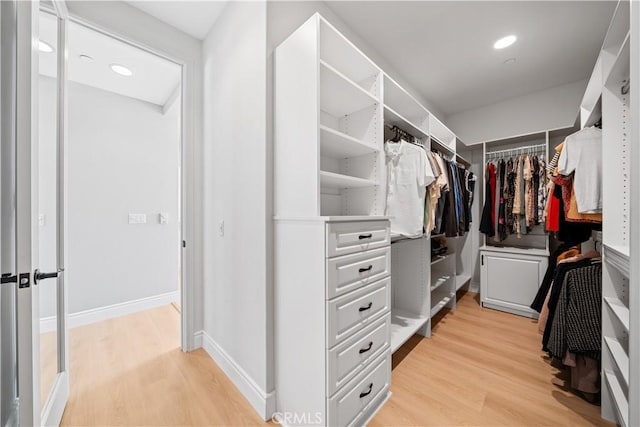 walk in closet with light wood-style flooring