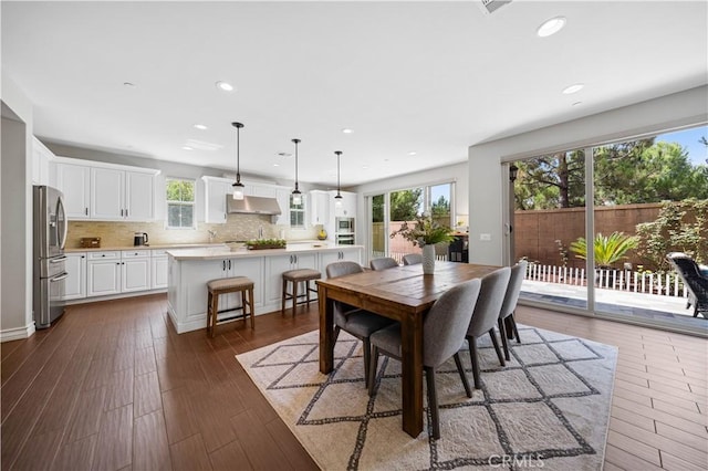 dining area with dark wood-type flooring and recessed lighting