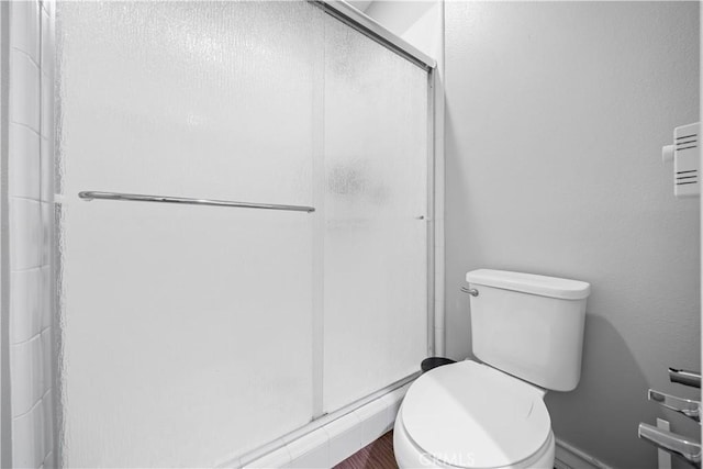 full bathroom featuring toilet and a stall shower