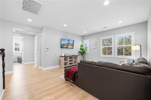 living area featuring baseboards, recessed lighting, visible vents, and light wood-style floors