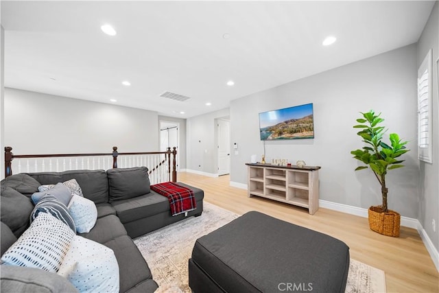 living room with recessed lighting, baseboards, visible vents, and light wood finished floors