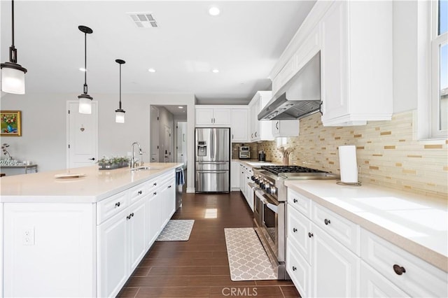 kitchen featuring dark wood finished floors, stainless steel appliances, visible vents, white cabinetry, and exhaust hood