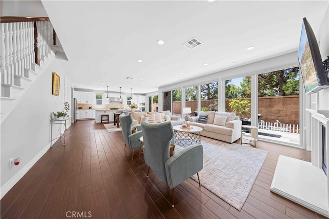 living room with dark wood-style floors, baseboards, visible vents, and recessed lighting