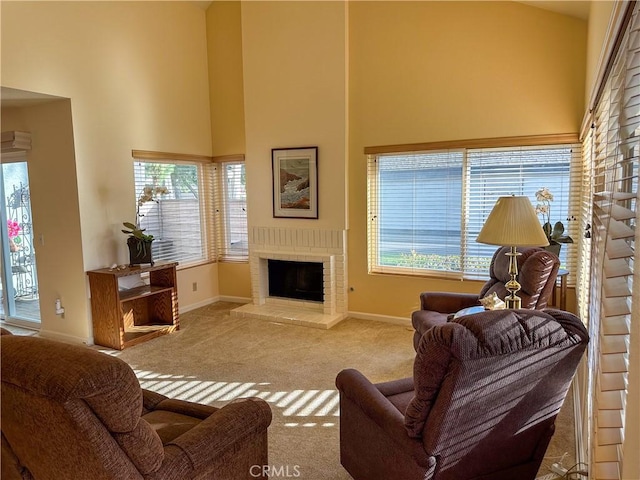 living area with carpet, baseboards, a fireplace, and a high ceiling