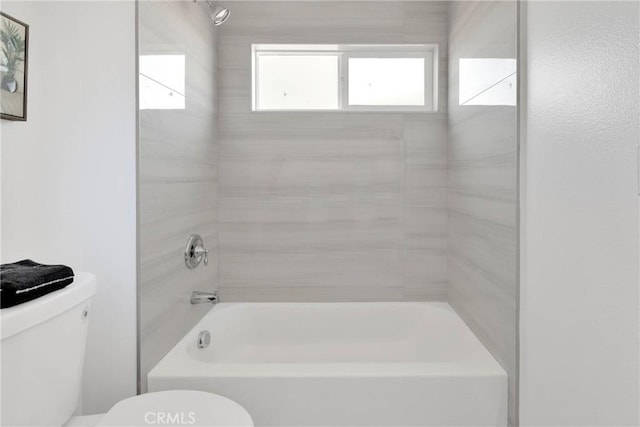 bathroom featuring bathing tub / shower combination and toilet