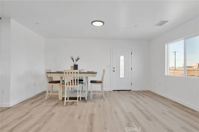 dining room with baseboards, visible vents, and light wood-style floors