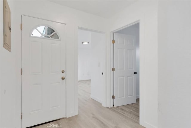 foyer entrance featuring light wood-style flooring and baseboards