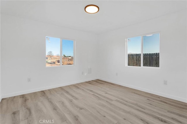 spare room with light wood-style floors and baseboards