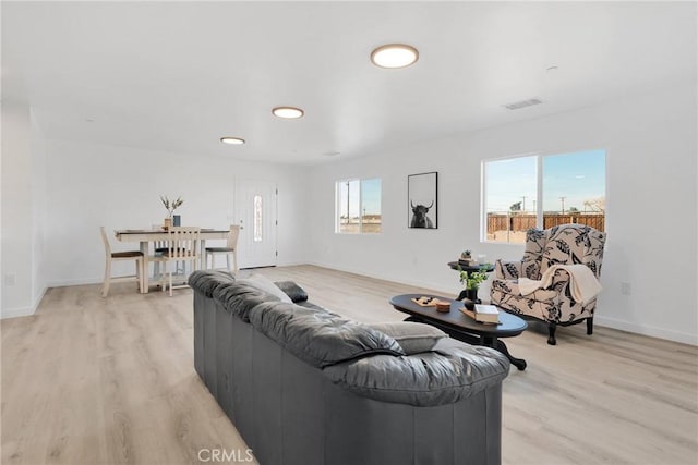 living area featuring baseboards, visible vents, and light wood-style floors