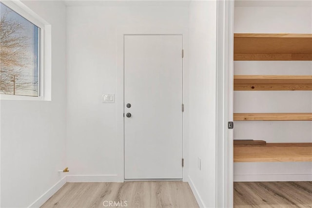 doorway to outside featuring light wood-style flooring and baseboards