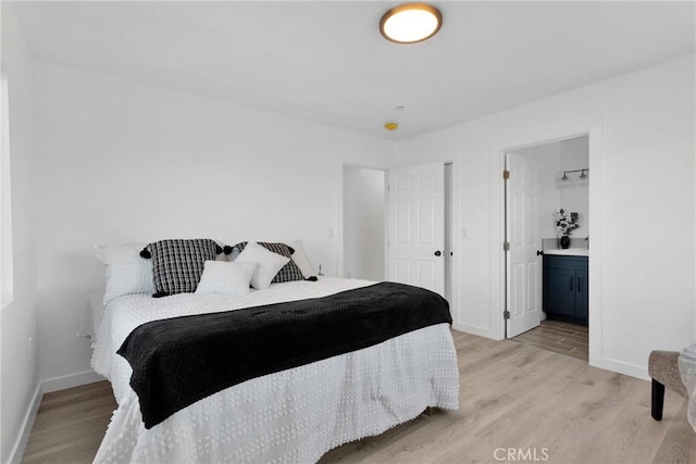 bedroom featuring light wood-type flooring, connected bathroom, and baseboards