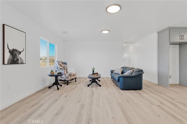 living area featuring light wood-type flooring and baseboards