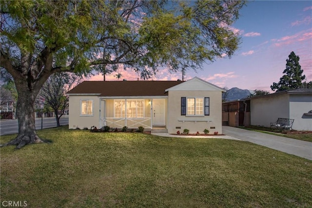 view of front facade with stucco siding, concrete driveway, and a front yard