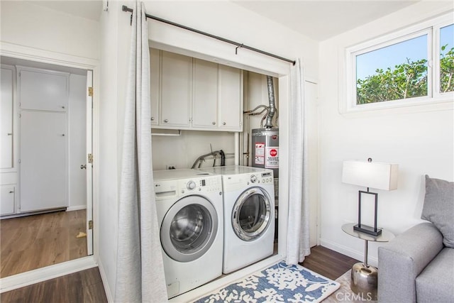 clothes washing area featuring separate washer and dryer, dark wood finished floors, cabinet space, and baseboards