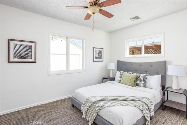 bedroom with carpet, visible vents, ceiling fan, a textured ceiling, and baseboards