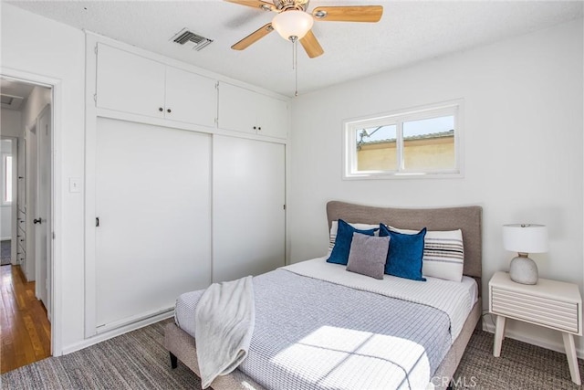 bedroom featuring a ceiling fan, visible vents, and a closet