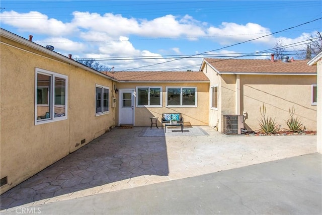 exterior space with central AC, a patio area, and stucco siding