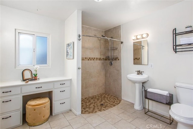 full bath with tiled shower, tile patterned floors, toilet, and baseboards