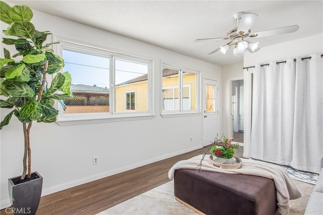 sitting room featuring a ceiling fan, dark wood finished floors, and baseboards