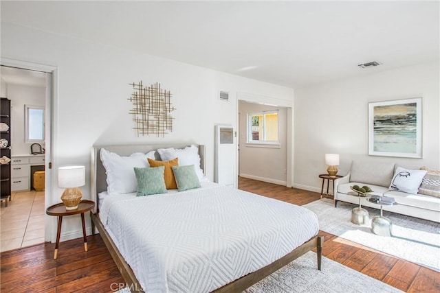 bedroom featuring dark wood-style flooring, visible vents, and baseboards