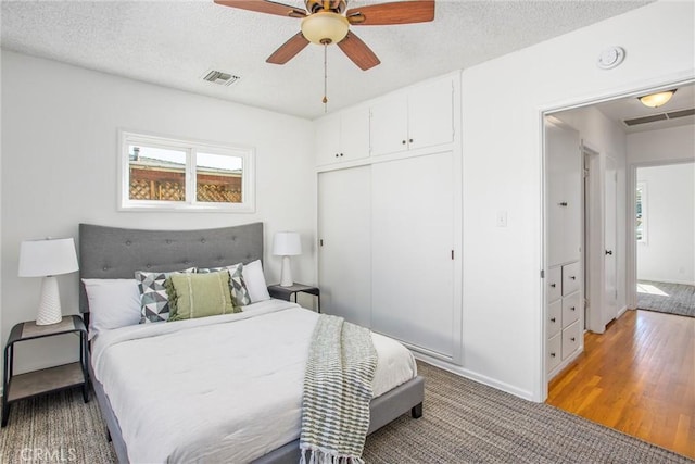 bedroom featuring a textured ceiling, a closet, and visible vents