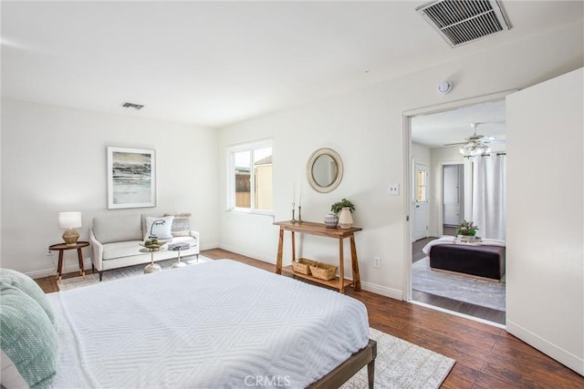 bedroom with dark wood-style flooring, visible vents, and baseboards