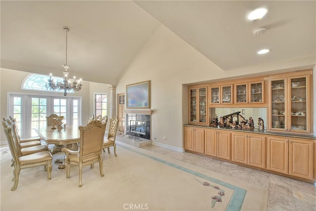 dining area featuring decorative columns, baseboards, a tiled fireplace, high vaulted ceiling, and recessed lighting