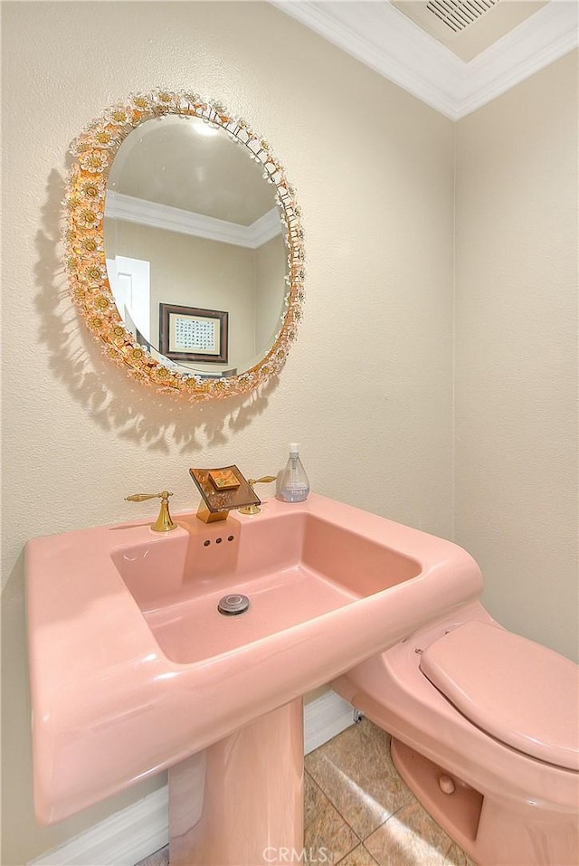 bathroom featuring tile patterned floors, a sink, toilet, and crown molding