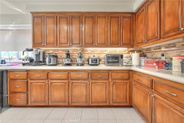 kitchen featuring light countertops, a toaster, brown cabinets, and decorative backsplash