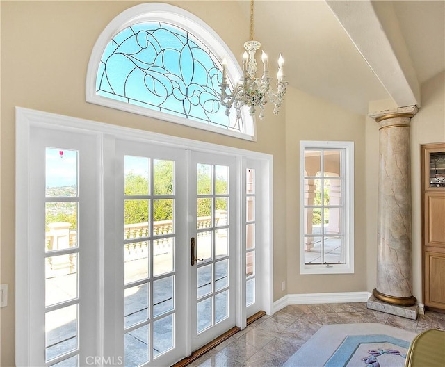 doorway with an inviting chandelier, french doors, baseboards, and ornate columns