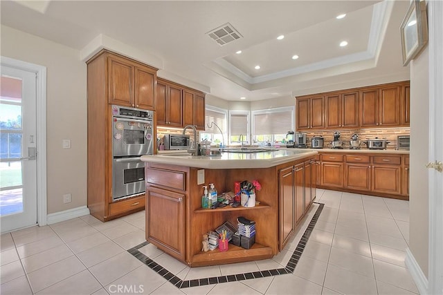 kitchen with stainless steel double oven, visible vents, light countertops, backsplash, and a raised ceiling