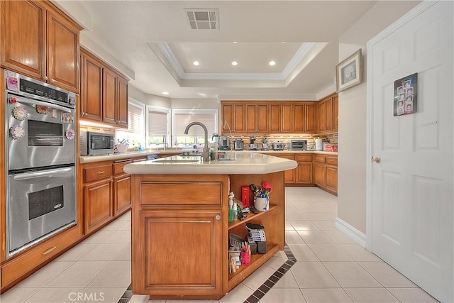 kitchen featuring light tile patterned floors, visible vents, a raised ceiling, appliances with stainless steel finishes, and light countertops