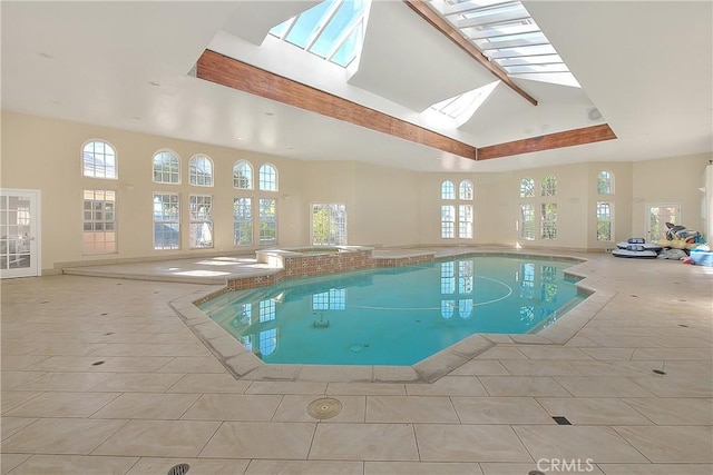 view of swimming pool featuring a skylight and a pool with connected hot tub