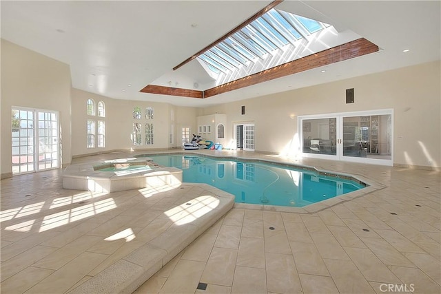 view of swimming pool with a skylight and a pool with connected hot tub