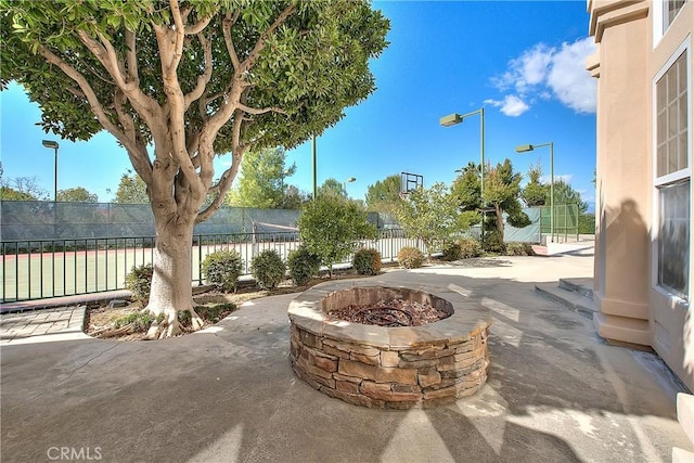 exterior space with an outdoor fire pit and fence