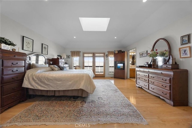 bedroom featuring access to outside, a skylight, light wood-style flooring, and recessed lighting