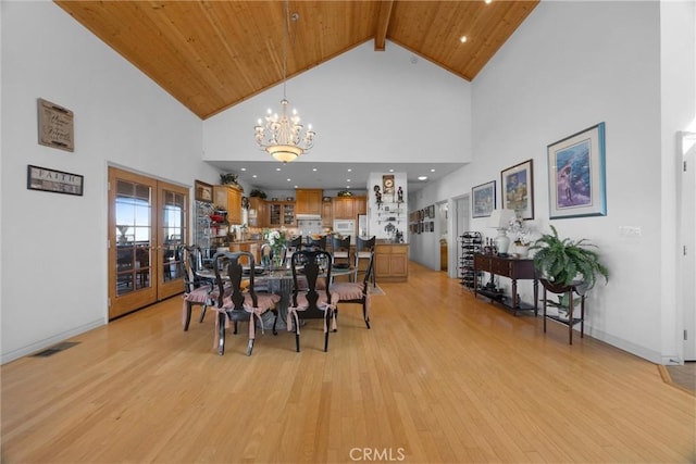 dining room with wood ceiling, french doors, light wood-style floors, a chandelier, and beam ceiling