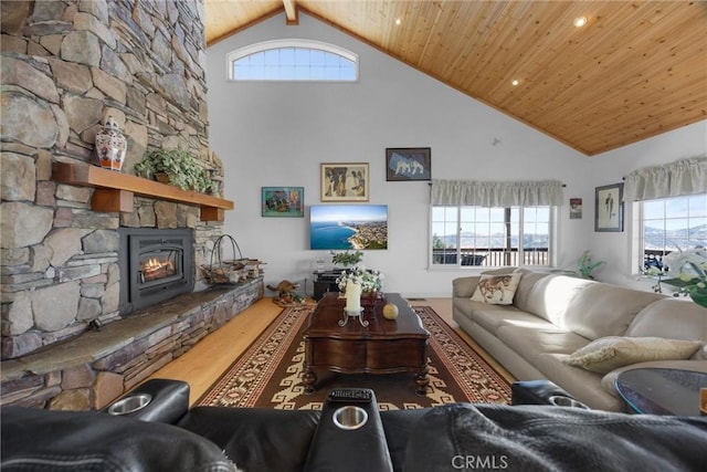 living room featuring wooden ceiling, plenty of natural light, wood finished floors, and a stone fireplace