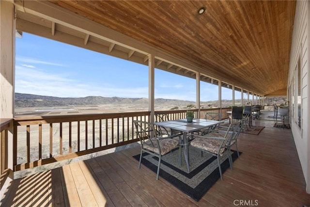 wooden deck featuring outdoor dining area and a mountain view